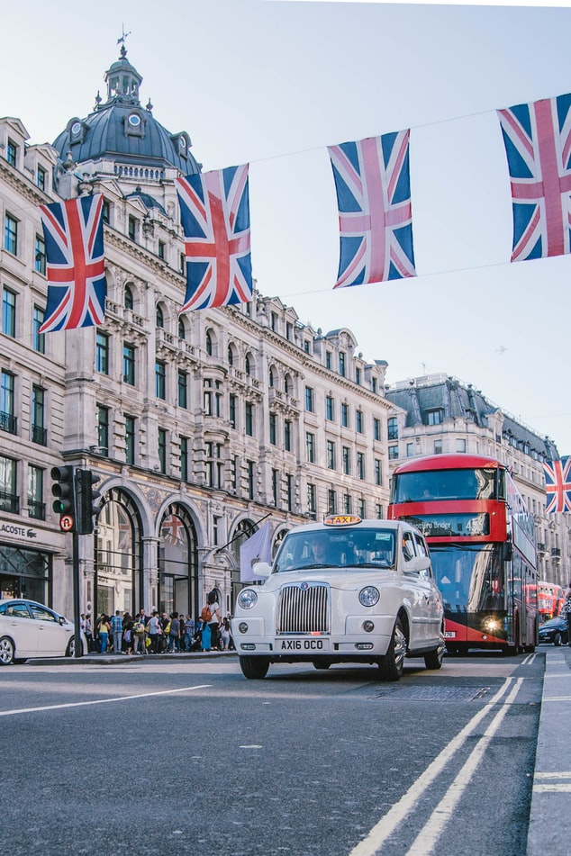 photographie d'une rue Londienne avec un taxi et un bus rouge