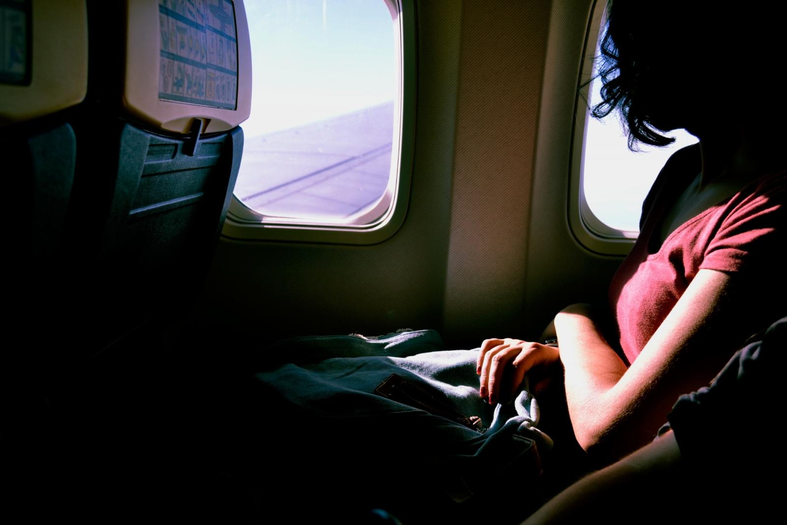 jeune femme regardant par le hublot d'un avion