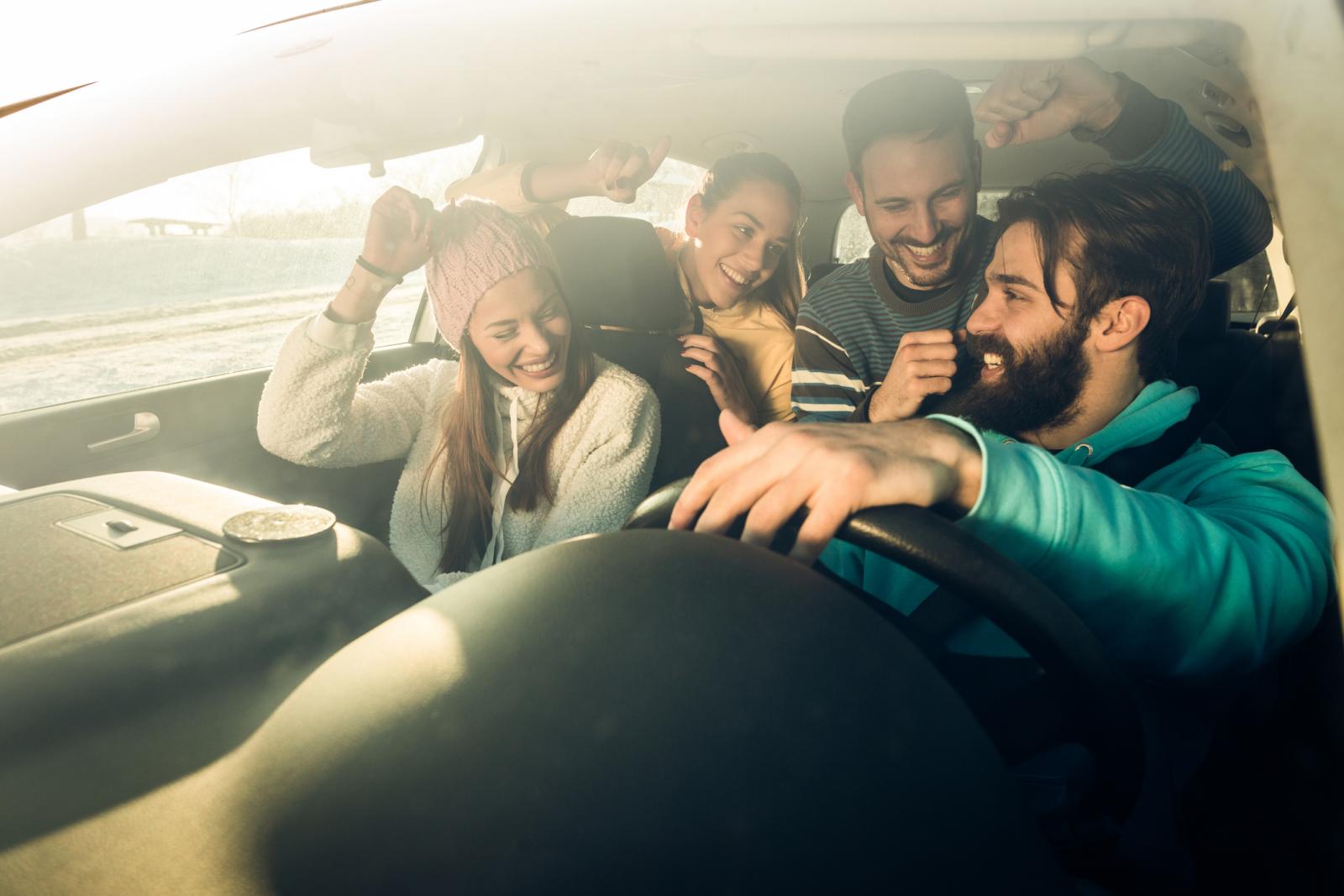 groupe de jeunes souriant dans une voiture