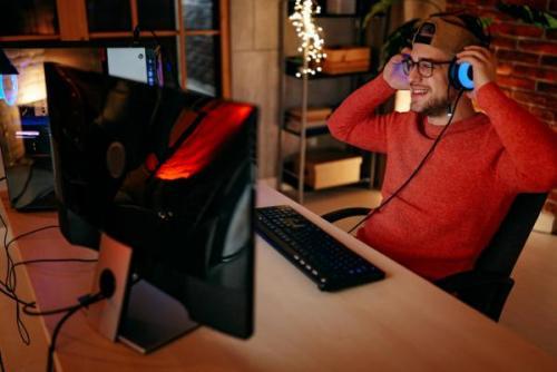 jeune homme assis devant un ordinateur gamer
