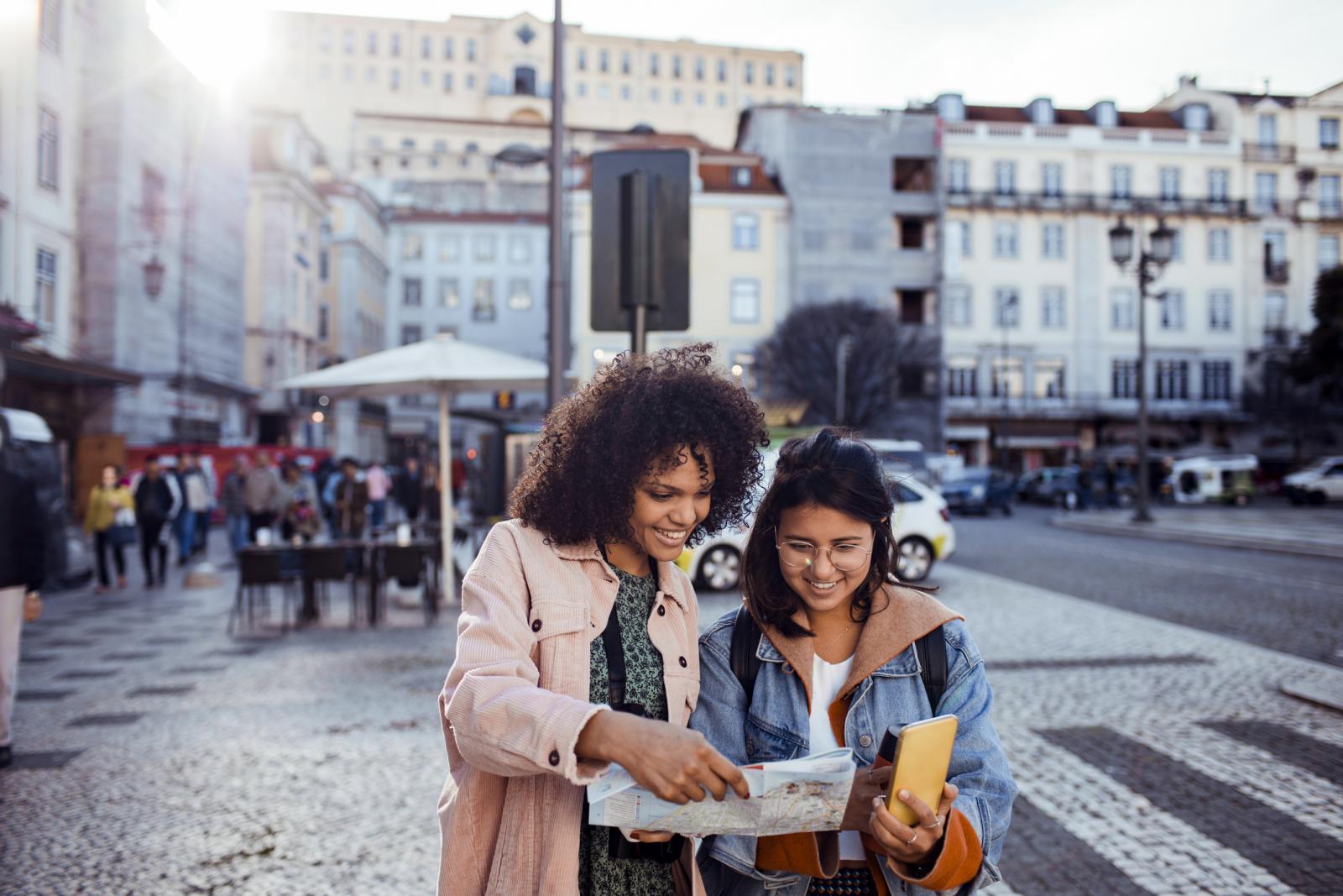 deux jeunes femmes regardant une carte dans une rue
