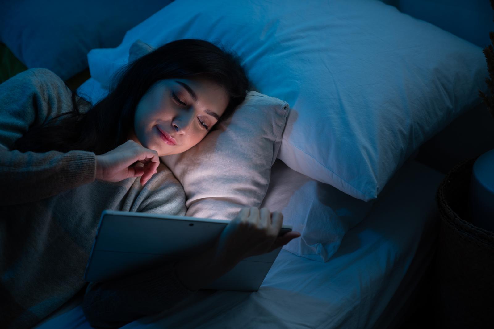 women using smartphone in bed